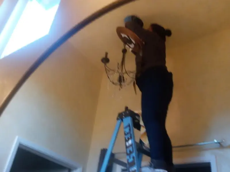 Electrician installing a chandelier in a Carlyss residence